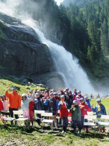 Eine Kindergruppe posiert vor den Krimmler Wasserfällen. - Foto: Tourismusverband Krimml