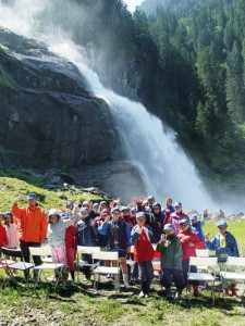 Eine Kindergruppe posiert vor den Krimmler Wasserfällen. - Foto: Tourismusverband Krimml