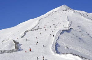 Beinahe kitschig, wie ein Gemälde, schaut der Gipfel des Speierecks aus; darunter tummeln sich viele Skifahrer. - Foto: Goldeck-Speiereck