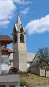 Der Campanile der Pfarrkirche Mariae Himmelfahrt von Serfaus kommt fast mediterran daher. Der frei stehende, 36 Meter hohe Kirchturm, steht der Überlieferung nach an der Stelle eines ehemaligen römischen Wachturms. Er trägt einen massiv gemauerten Steinhelm. – Foto: Dieter Warnick