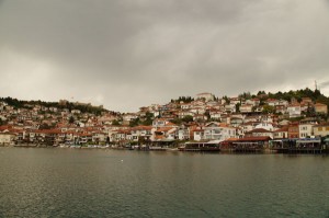 Blick auf Ohrid und den Hafen von der Wasserseite aus. Die kleine Stadt Ohrid drängt sich die  Hügel der Ausläufer des Korab-Gebirges. 