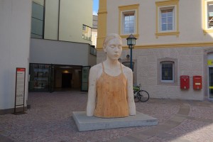 Um allen Kunst-Interessierten die Möglichkeit zu geben, Arbeiten der großen Grödner Künstler zu bestaunen, hat man im Kongresshaus von St. Ulrich die Dauerausstellung ART52 eingerichtet, die sich vollends der Holzbildhauerei und -schnitzerei widmet. Diese Skulptur weist den Weg. – Foto: Val Gardena-Gröden Marketing