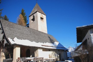 Alle Wege führen nach St. Helena; das bezaubernde Hügelkirchlein kann sowohl im Sommer als auch im Winter ohne Probleme zu Fuß angesteuert werden. Rechts der Kreuzhof. – Foto: Herbert Pichler 