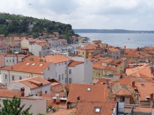 Wo heute der Tartini-Platz liegt, war früher ein Fischerhafen. Der Platz ist der zentrale Ort von Piran; zahlreiche schmucke Häuser und Palazzi bilden das passende Ambiente; er wird dominiert vom Gemeindepalast (links) und der auf einem Hügel stehenden Kirche St. Georg. – Foto: Dieter War