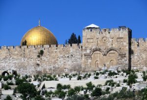 In Jerusalem wird die imposante Tempelmauer unterbrochen durch das Goldene Tor, durch das der Messias, wie die Juden glaubten, die Stadt betrete. Deshalb und aus strategischen Überlegungen vermauerten die Araber das Tor und legten einen Friedhof davor an. Links neben dem Tor die vergoldete Aluminium-Kuppel des Felsendoms.