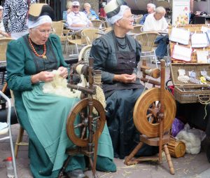 Auf dem Markt in Schagen versammeln sich jeden Donnerstag in den Sommermonaten viele Frauen und Männer in den traditionellen Trachten Nordhollands und veranschaulichen, wie es vor hundert Jahren war. Hier zeigen zwei Frauen, wie gesponnen wird.