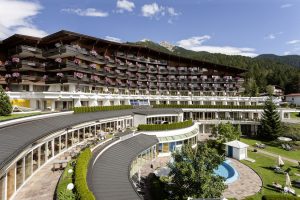 Außenfassade mit Blumenschmuck. - Foto: Krumers Alpin Resort & SPA