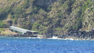 Bounty Bay mit Bootsschuppen und der einzigen Landestelle auf Pitcairn, der letzten britischen Kolonie im Pazifik. Die Einwohner der Insel sind zum Teil Nachfahren der Meuterer von der Bounty und ihrer polynesischen Frauen.