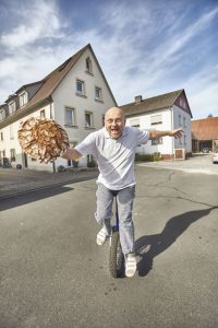 Sportlich, sportlich, und Bäcker mit Leib und Seele: Arnd Erbel balanciert auf dem Einrad einen Laib Bauernbrot. - Foto: www.bayern.by / Gert Krautbauer