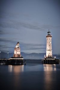 Löwe und Leuchtturm im Abendlicht. Der „Lindauer Löwe“ (links) ist neben dem neuen Leuchtturm das Denkmal, das die Lindauer Hafeneinfahrt charakteristisch prägt. Sie gilt als Wahrzeichen der Stadt und schönste Hafeneinfahrt am gesamten Bodensee. – Foto: Hari Pulko / Lindau-Tourismus