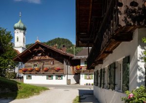 Der Malerwinkel in Farchant mit der Pfarrkirche St. Andreas und dem Bauernhaus „Beim Krin“ ist ein begehrtes Fotomotiv. Das Gebäude ist das älteste Haus in Farchant; der Name geht auf die Familie Krin (1480–1650) zurück. – Foto: Tourist-Info Farchant / Andreas Müller