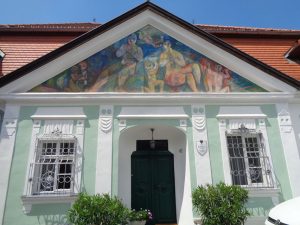 Das ehemalige Baderhaus in Dürnstein hat einen Baukern von 1668 und eine klassizistische Fassade um 1800. Im Dreiecksgiebel befindet sich ein modernes Fresko von Maximilian Melcher, das er 1963 schuf und eine Musikantenfamilie darstellt. – Foto: Dieter Warnick