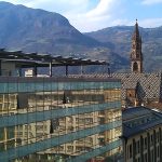 Bozen ist auch eine Stadt der Gegensätze: Blick von der Dachterrasse des Hotels Falkensteiner auf das gegenüberliegende moderne Glasensemble und den gotischen Dom Maria Himmelfahrt am Waltherplatz. – Foto: Dieter Warnick